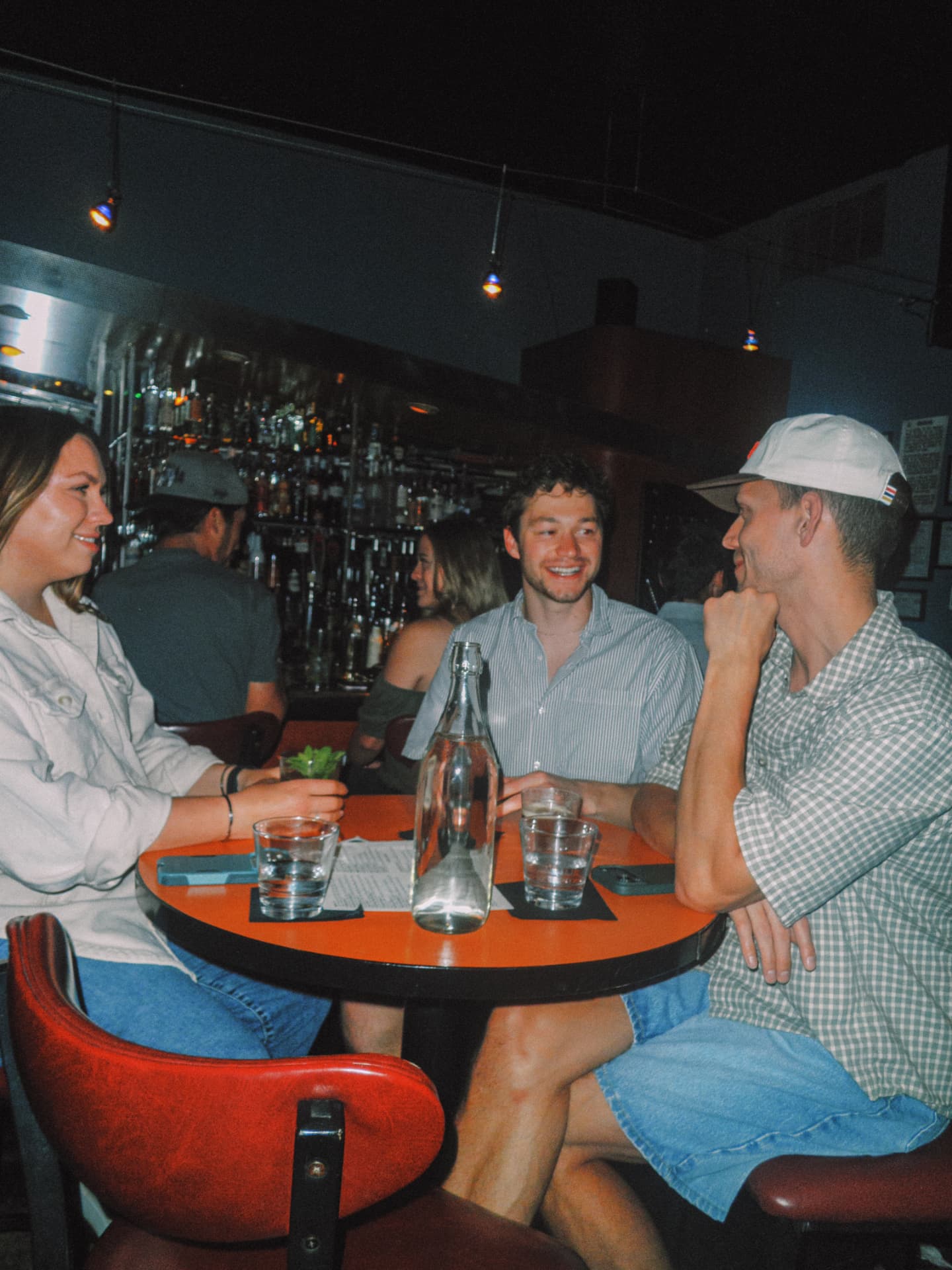 Three friends at a table in front of the back bar