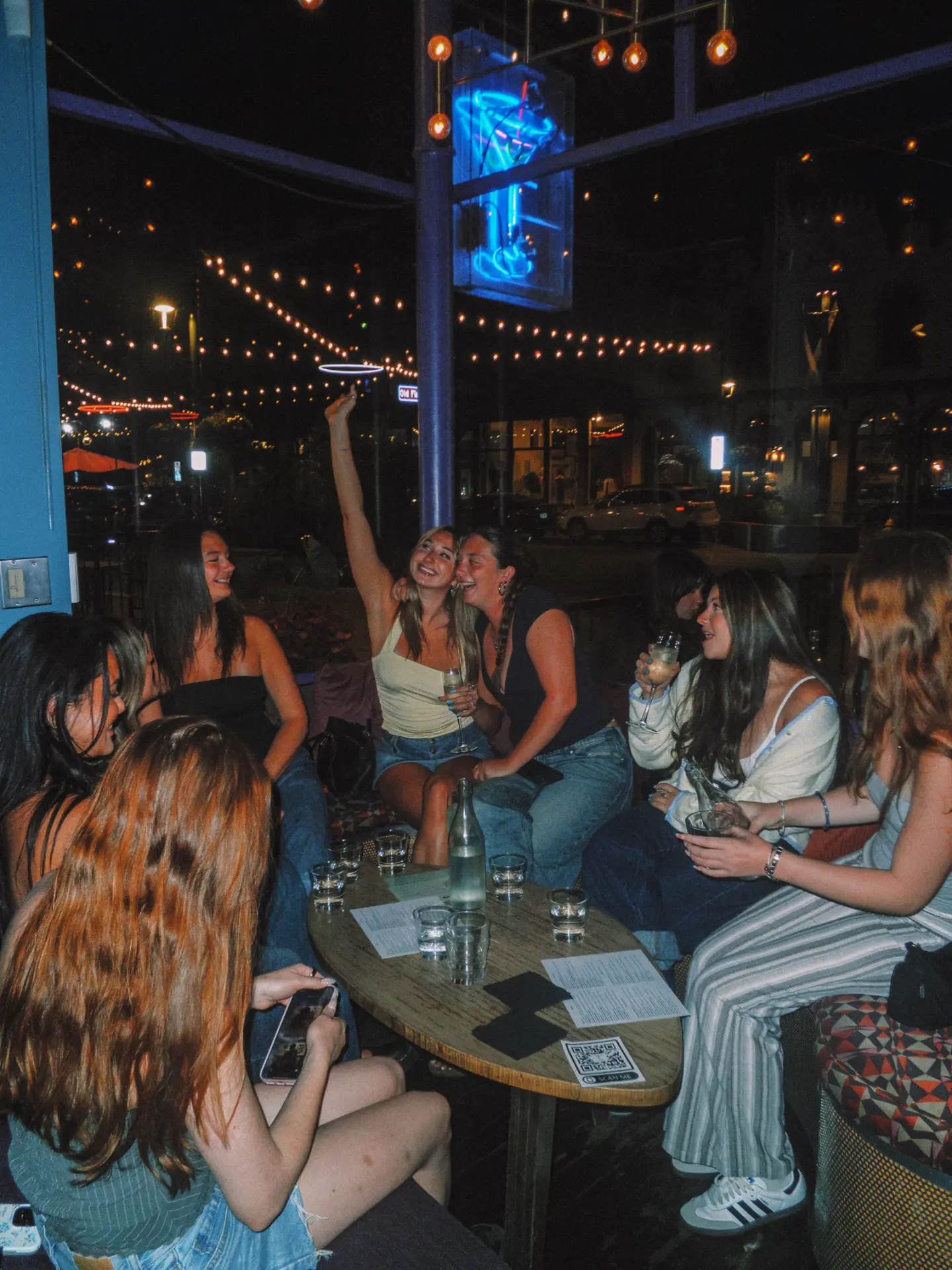 Group of friends toasting around a patio table at Elliot's