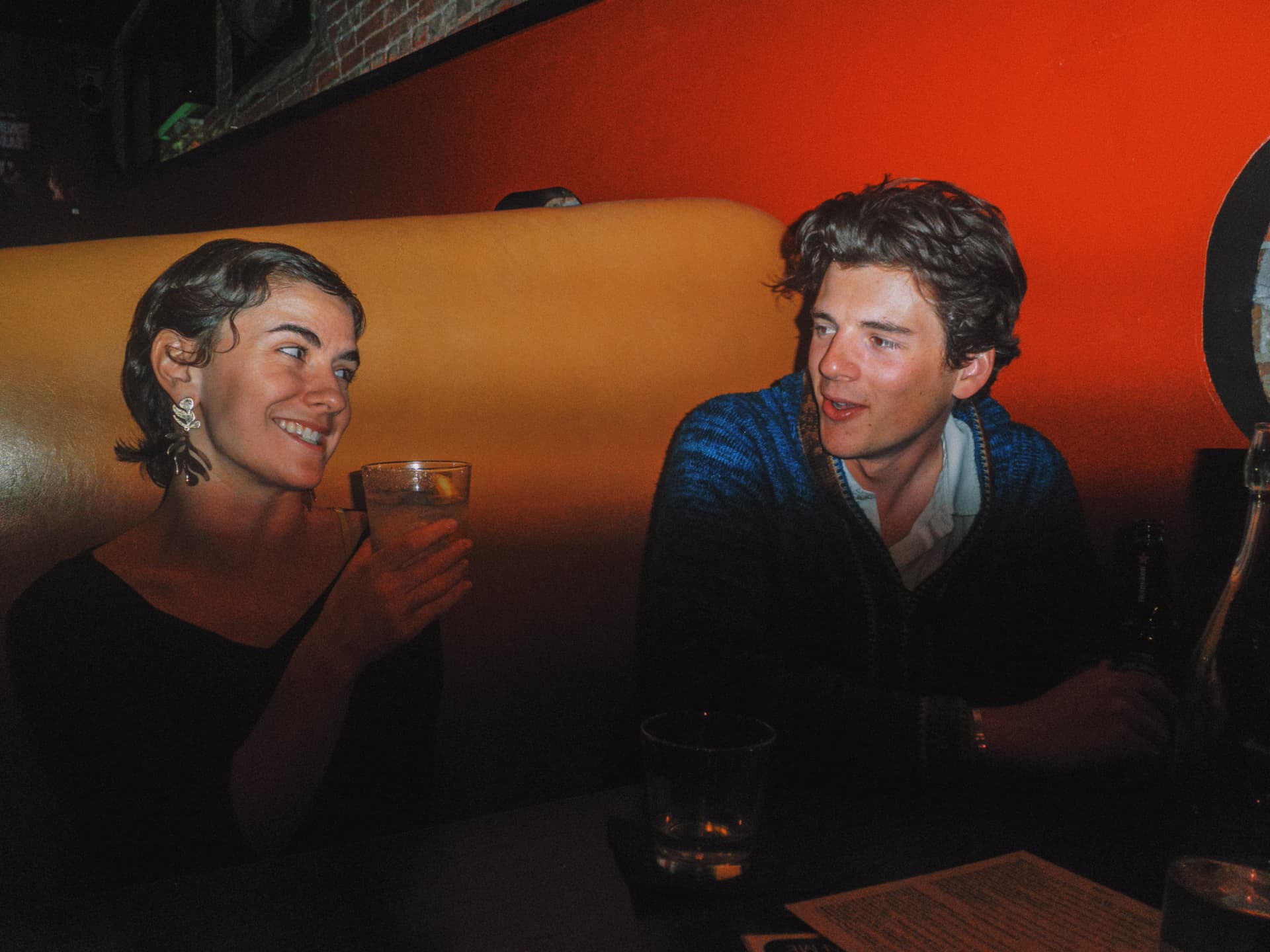 Two guests laughing together in the booth at Elliot's